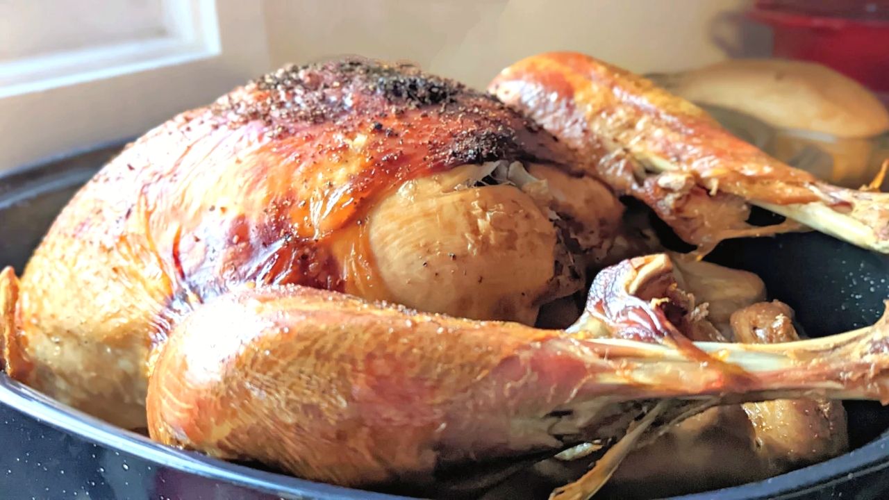 salt free turkey in a roasting pan with crispy skin and juicy meat and fresh herbs.