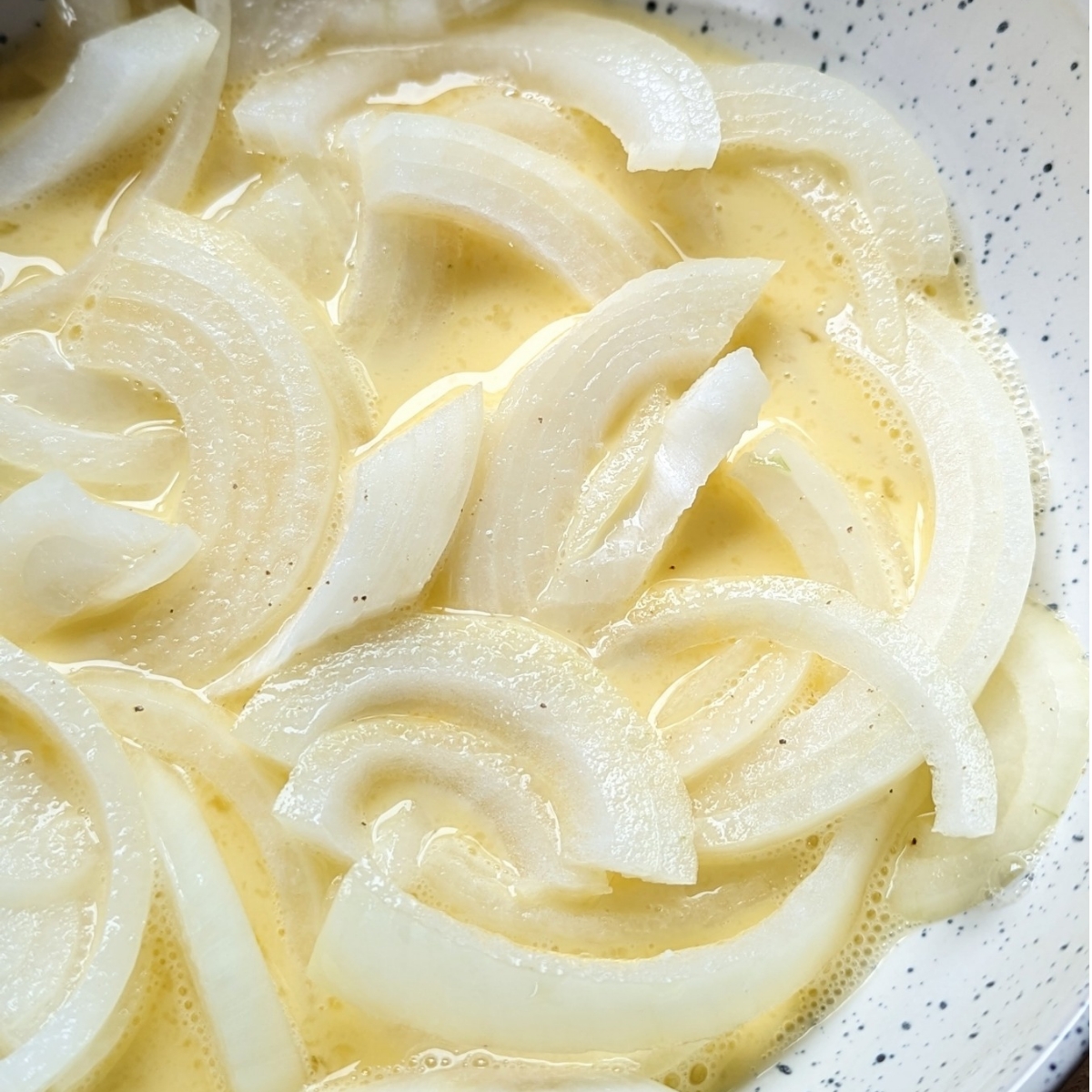 thinly sliced sweet yellow onions soaked in an  egg and milk mixture then tossed in flour and breadcrumbs