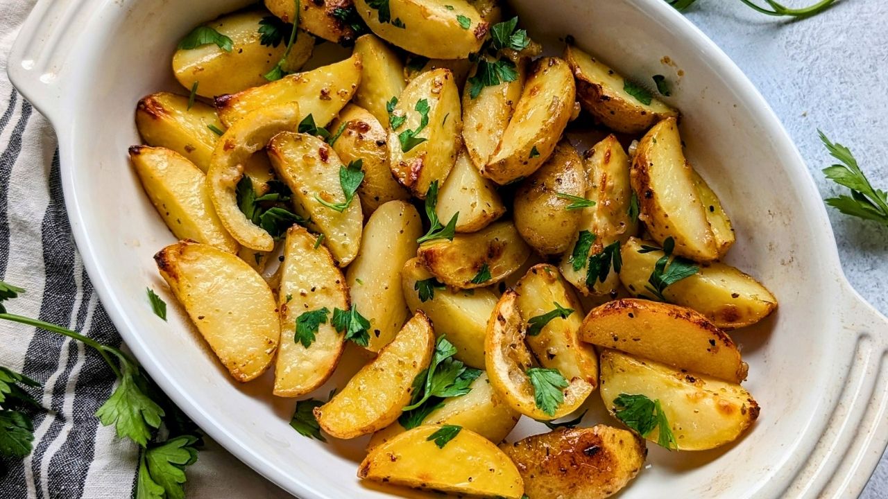 a baking dish filled with golden brown no salt added potatoes baked in olive oil and lemon juice and tossed with fresh parsley