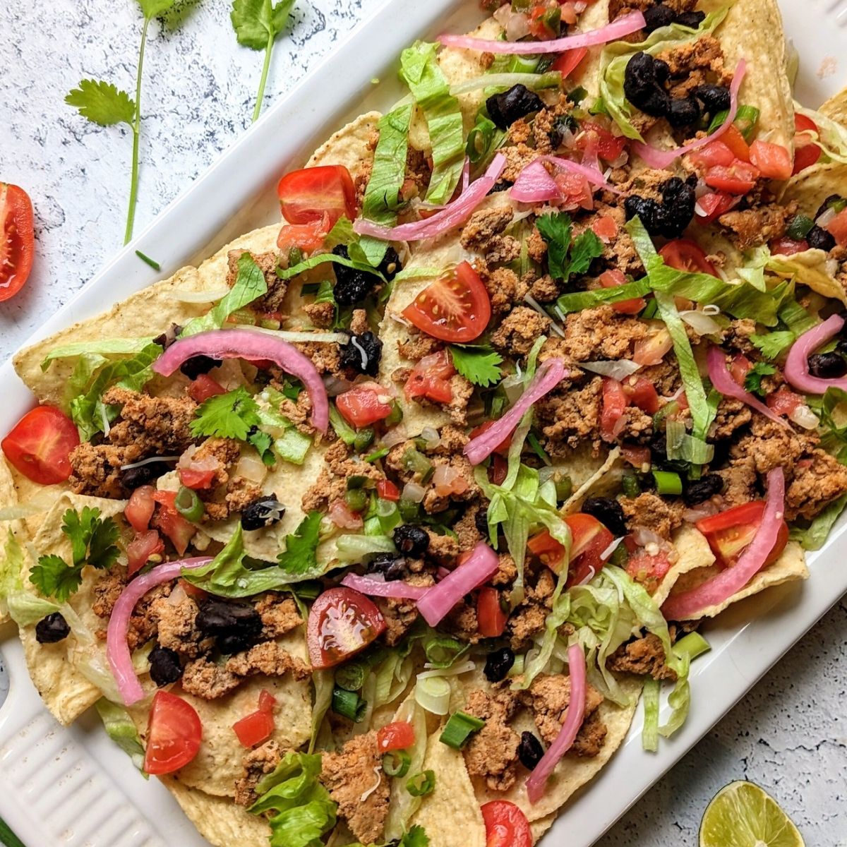 low sodium nachos recipe with unsalted tortilla chips, black beans, cilantro, salsa, and tomatoes