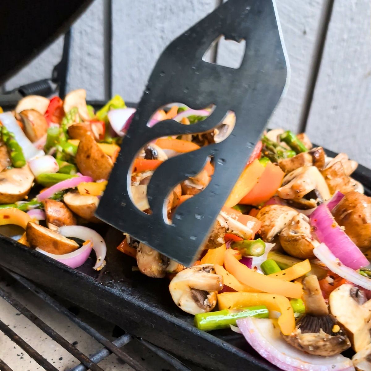 a spatula tossing bell peppers, mushrooms, and onions without salt.