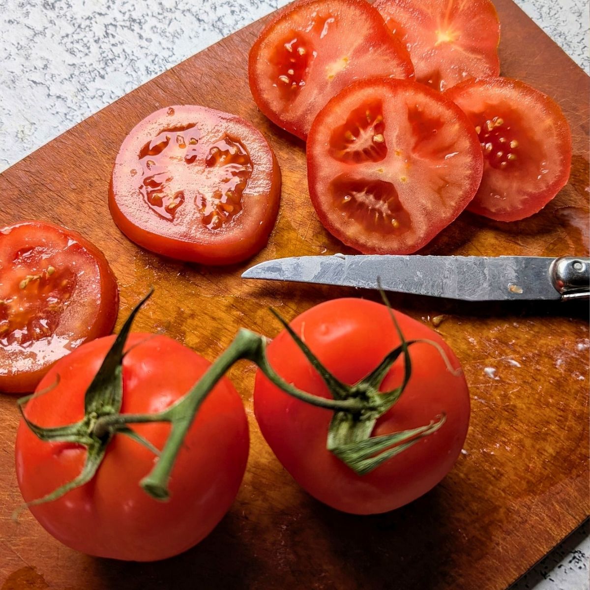 sliced tomatoes on a cutting board thickly sliced fresh garden tomatoes.