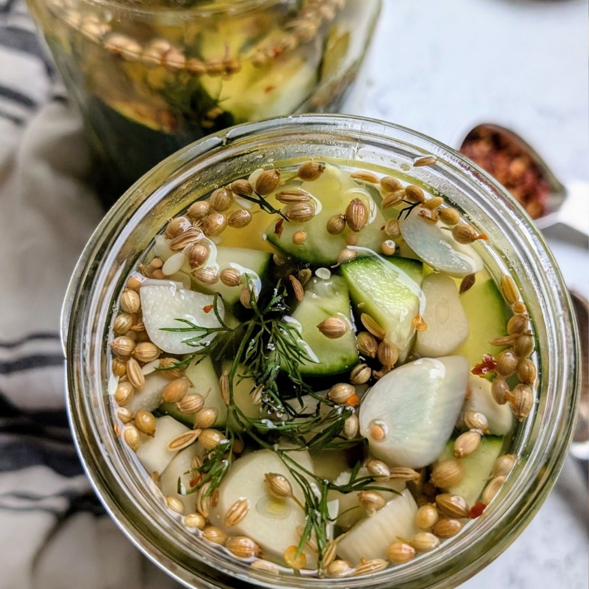 a jar of pickles with garlic and spices unsalted pickles with brine.