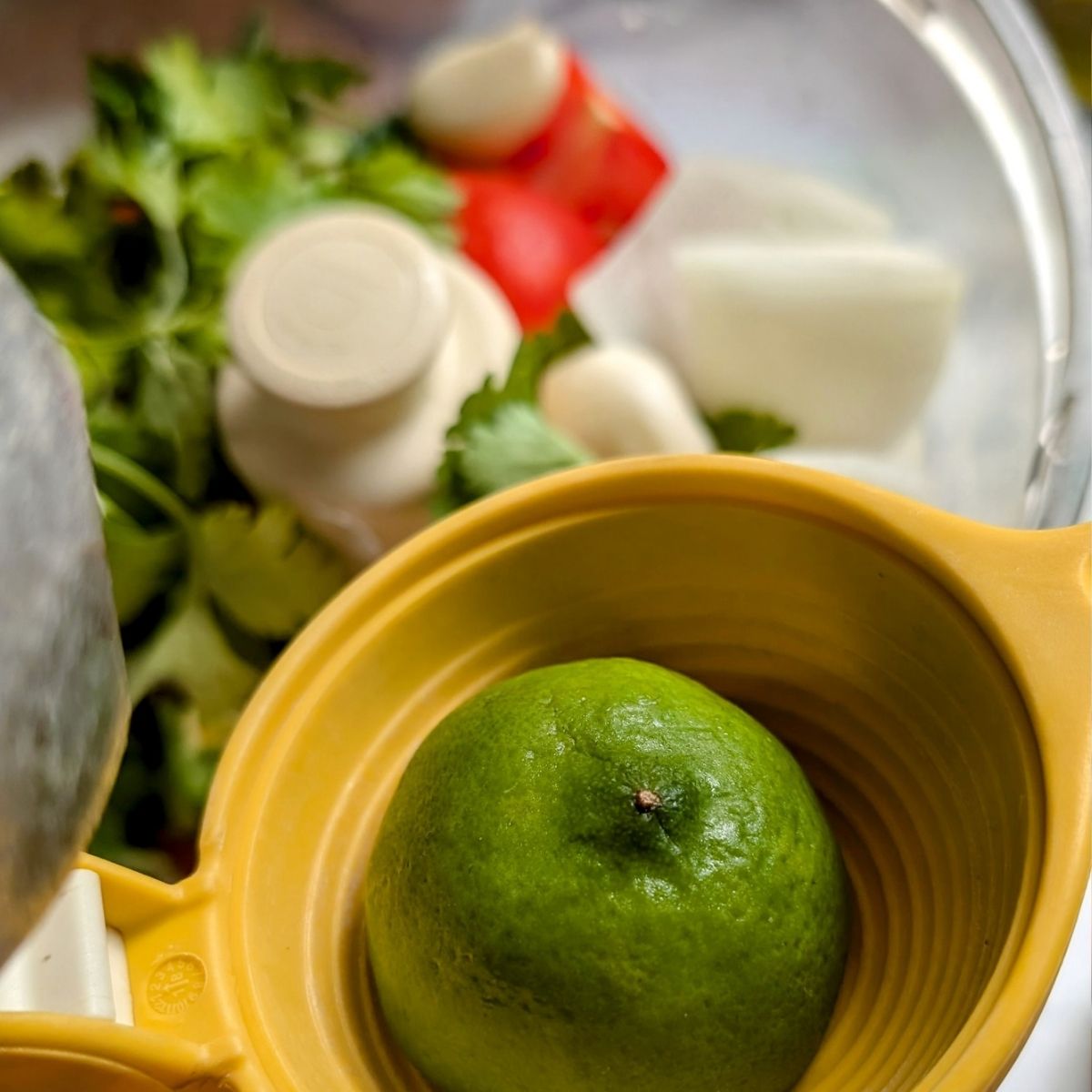 fresh lime in a citrus juicer being added to homemade salsa without salt.