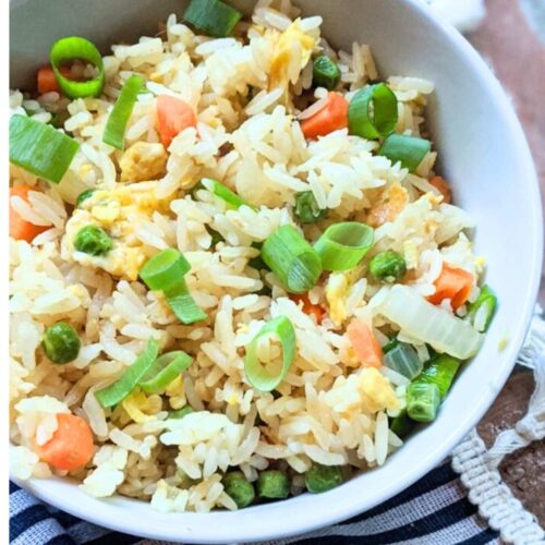 a bowl of low sodium fried rice with vegetables, eggs, and sriracha!