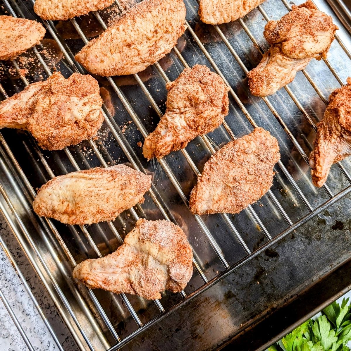 spicy chicken wings on a baking speet coated in spices without salt.