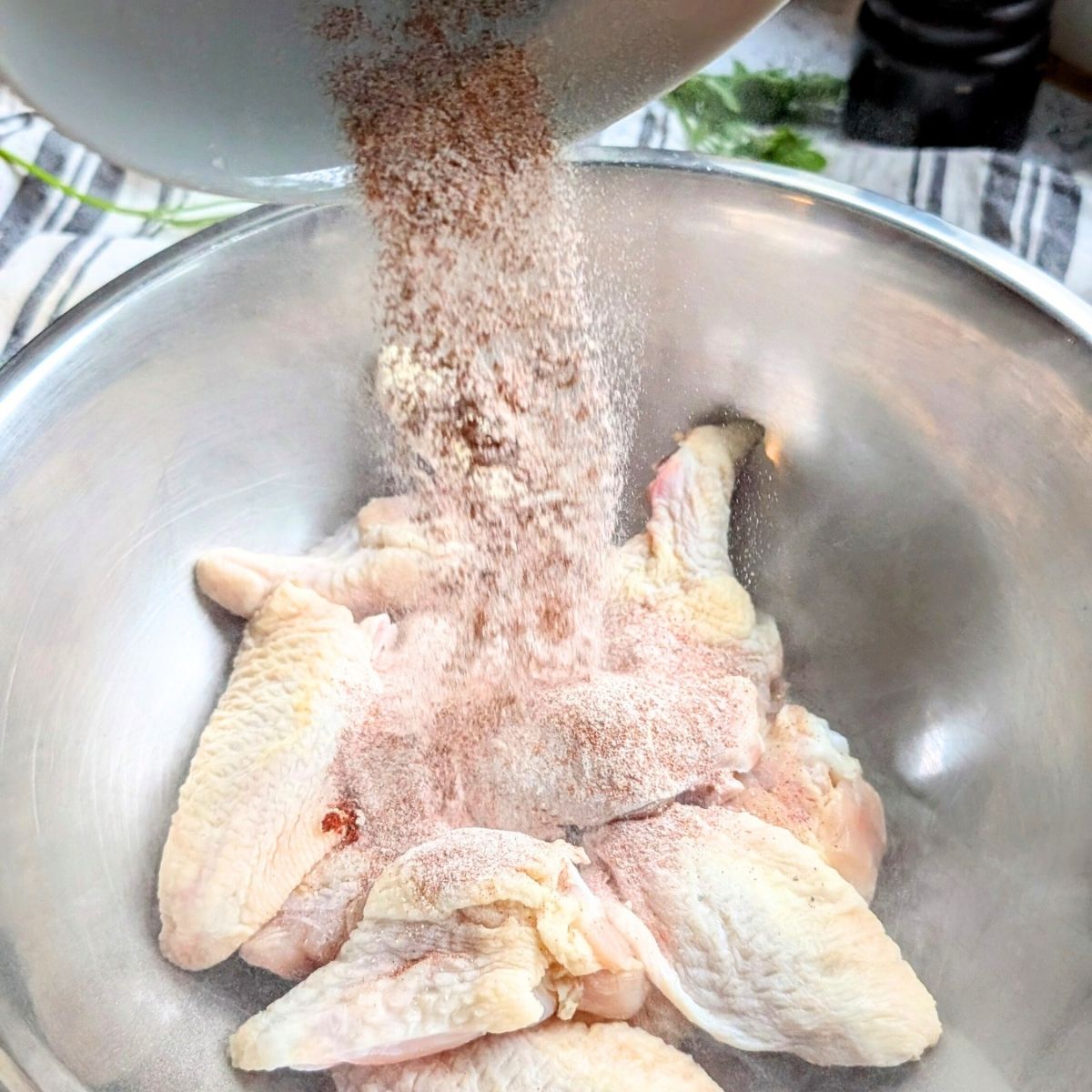 Place the chicken wings in a bowl, and pour the spice blend over the chicken wings.