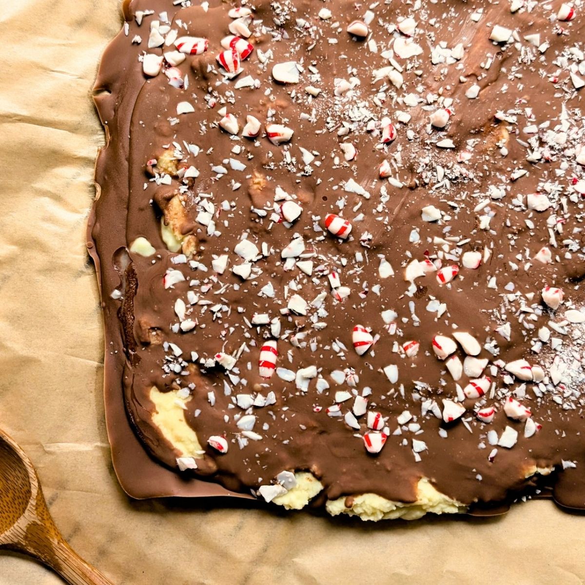 a slab of chocolate pepper mint bark with white chocolate and mil chocolate with crushed mints on top.