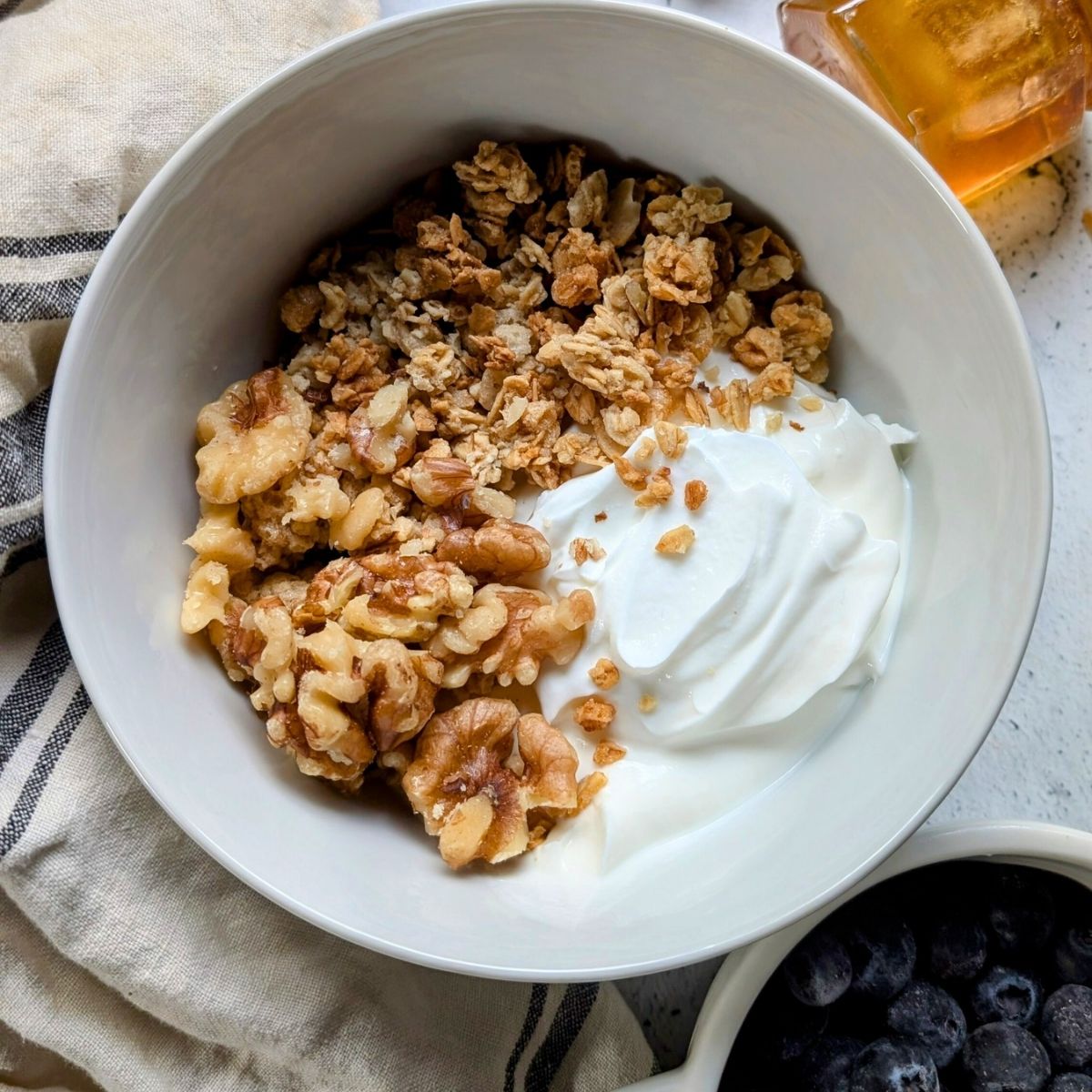 a breakfast bowl with low sodium yogurt, walnuts, and granola for a healthy breakfast idea.