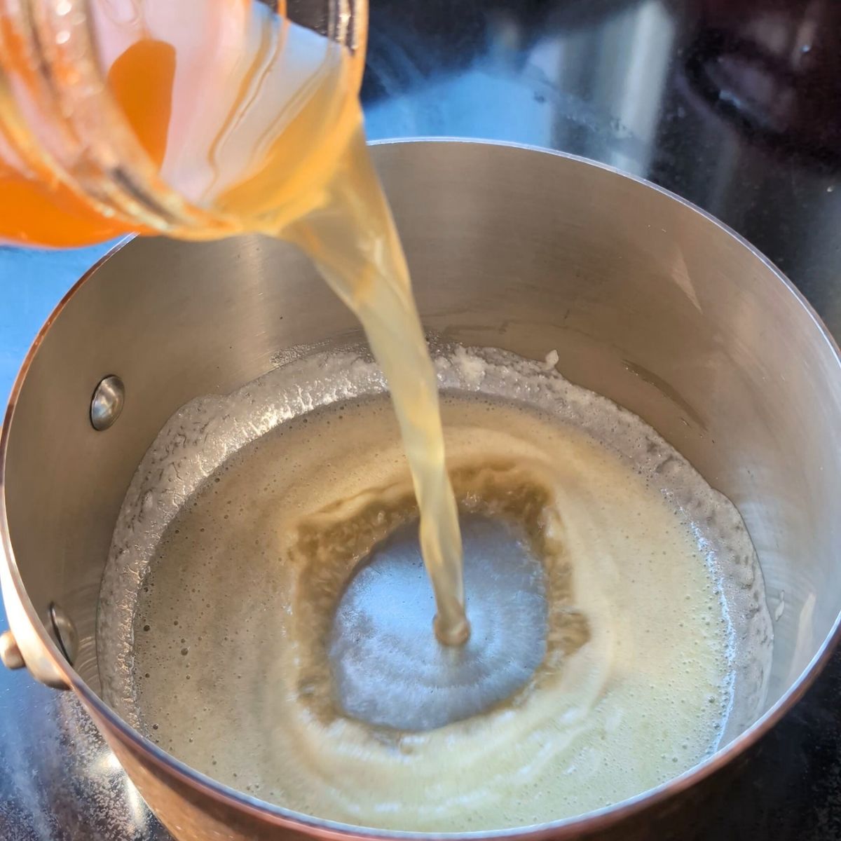 low sodium chicken stock or turkey drippings being added to the roux to make low salt gravy recipe.