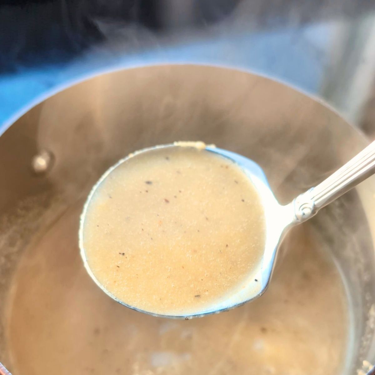 a ladle full of no salt added gravy for low sodium thanksgiving recipes like turkey or roast beef.