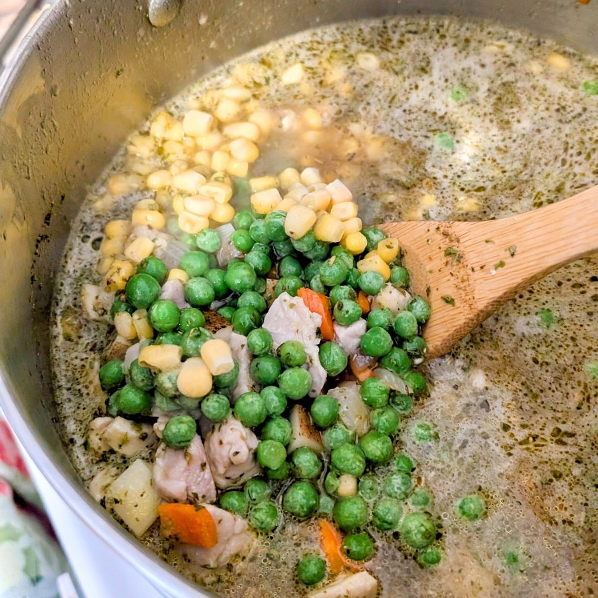 corn and peas added to a large pot of chicken and dumplings with no added salt