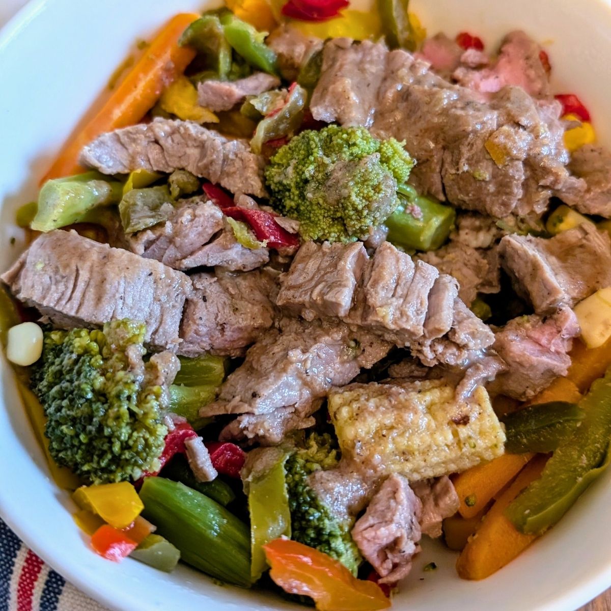 a bowl of low sodium beef and broccoli stir fry with corn and bell peppers.