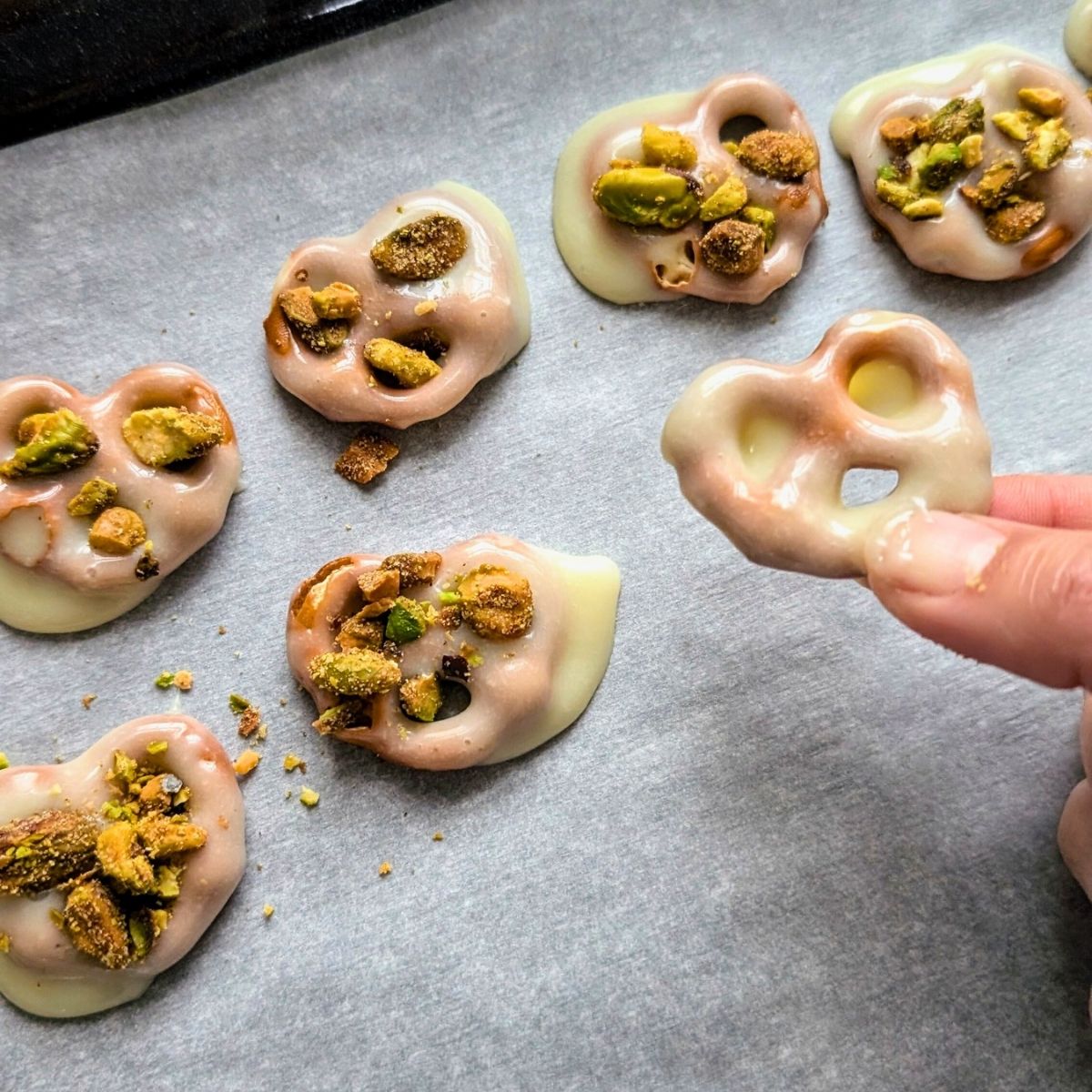 a tray of white chocolate covered low sodium pretzels topped with nuts