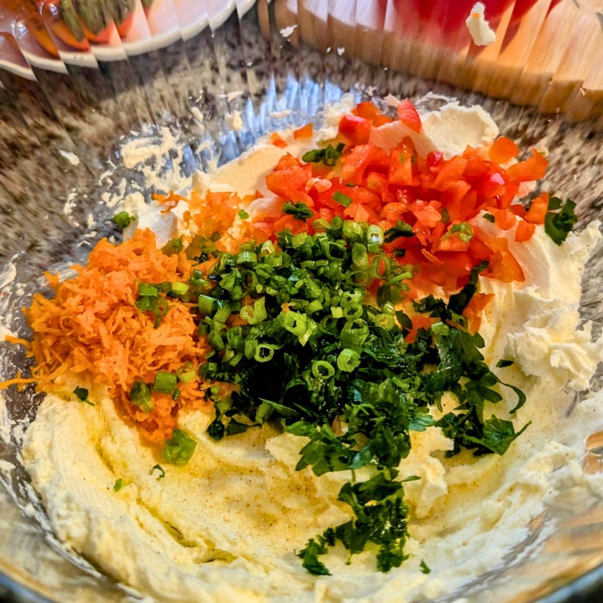 whipped cream cheese with carrots, bell pepper, green onion, and parsley