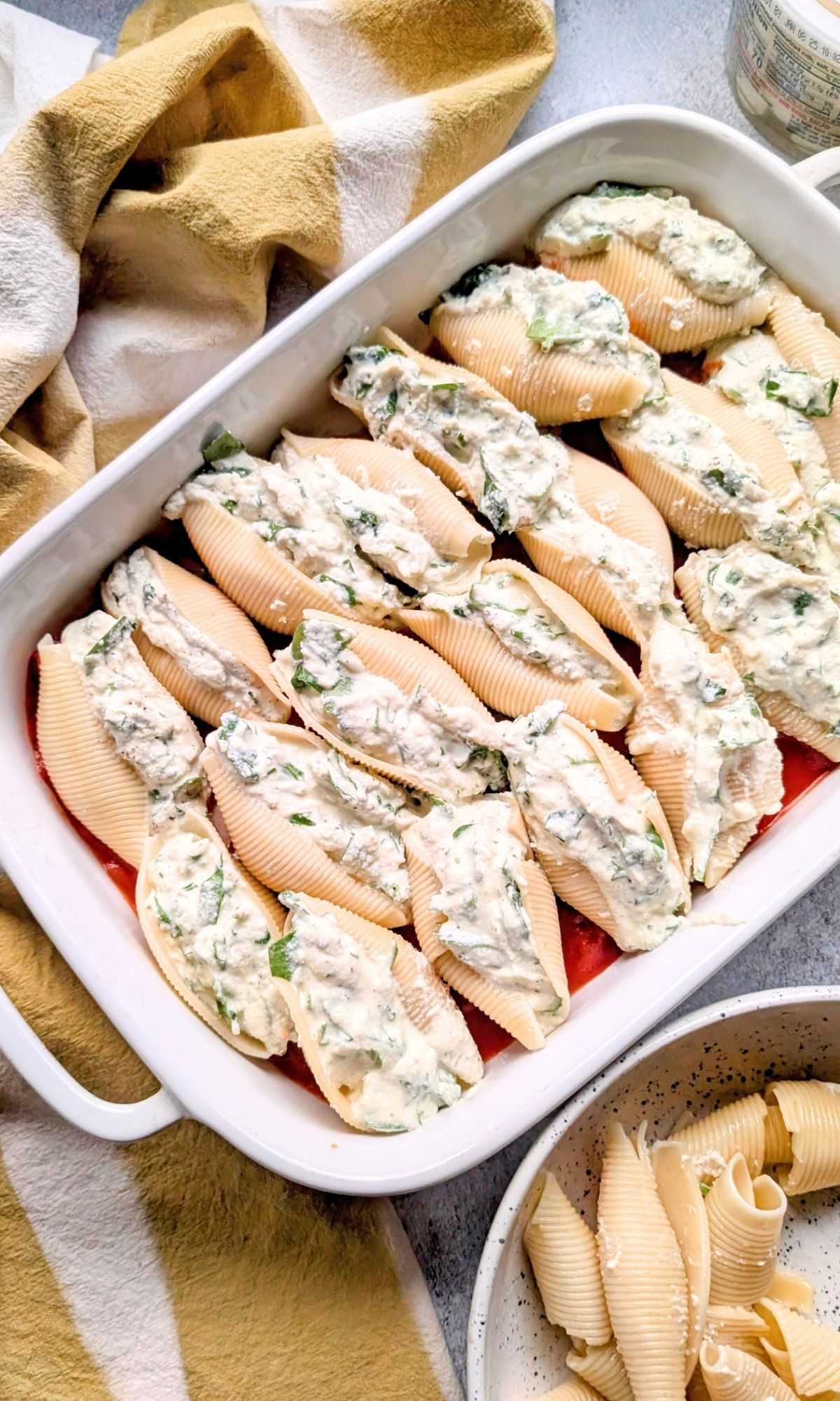 a plate of stuffed shells in a baking dish with tomato sauce as the base for a low sodium stuffed pasta