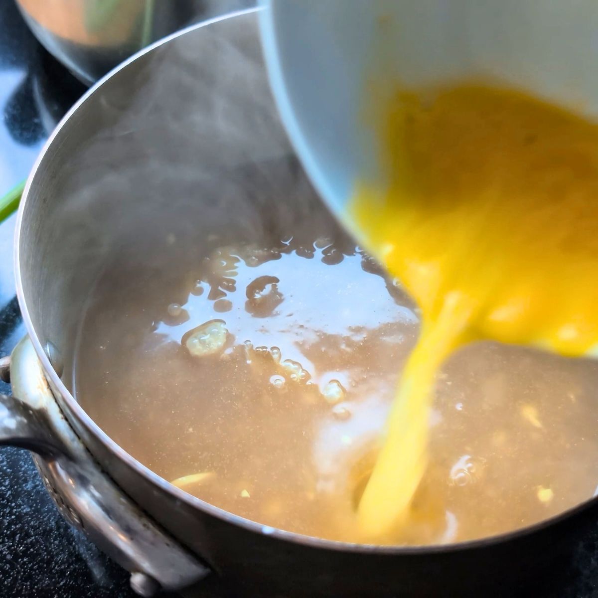 eggs being folded into chicken broth to make no-salt-added egg drop soup