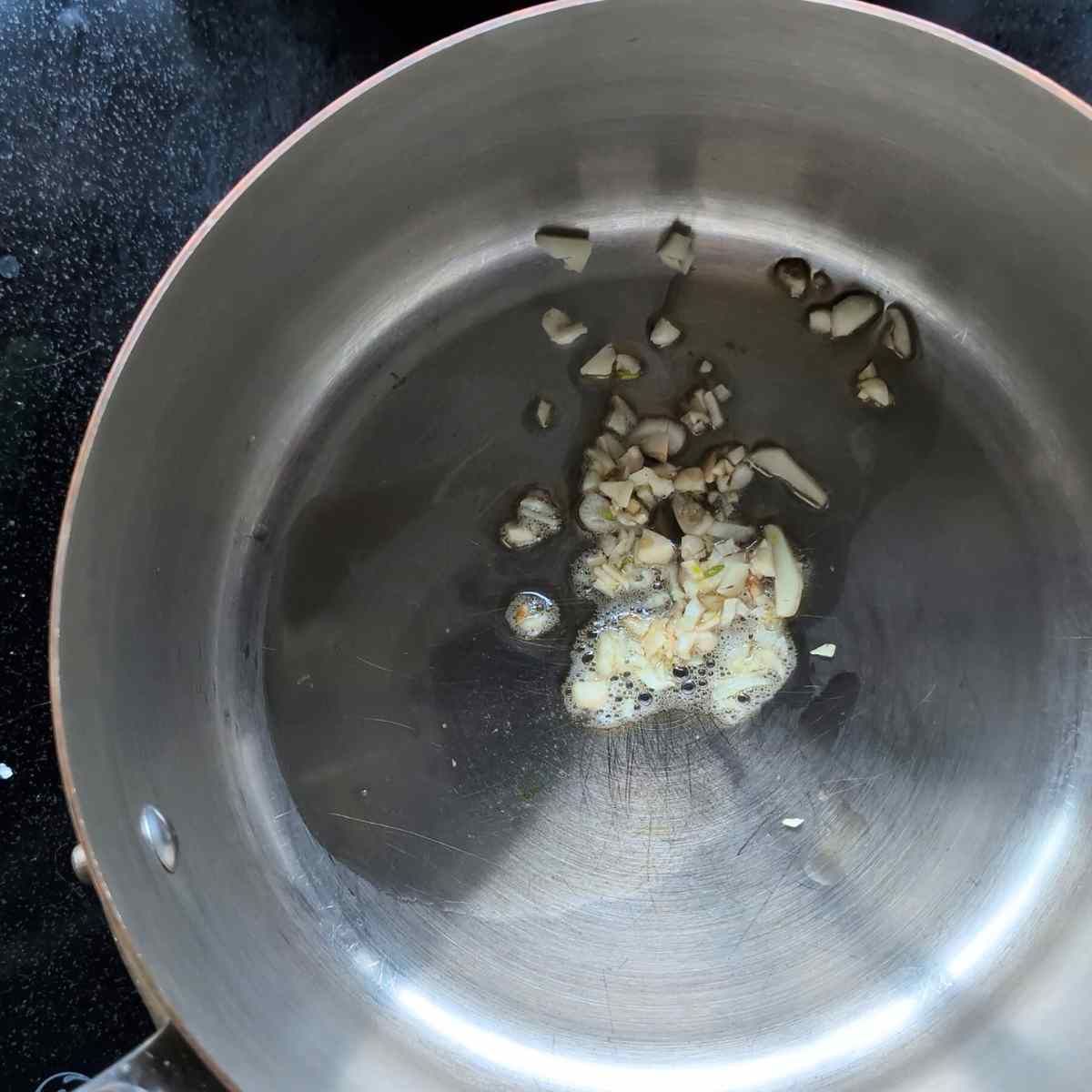 garlic and toasted sesame oil in a pan browning to make low sodium egg drop soup