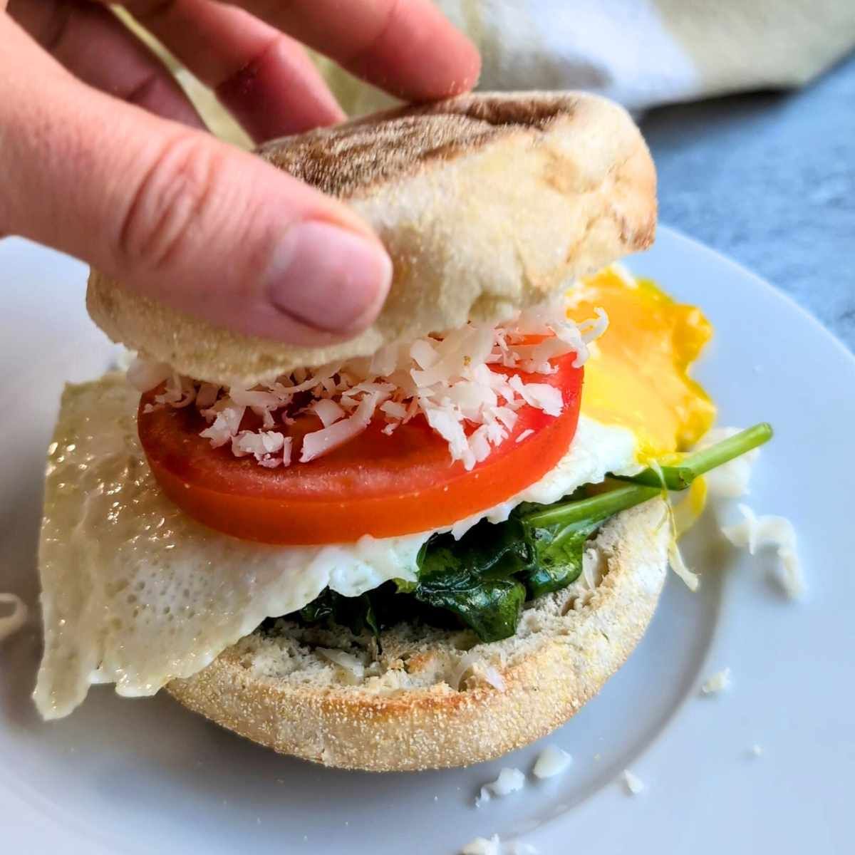 low sodium breakfast sandwich with eggs, english muffins, tomato, cheese, and spinach.