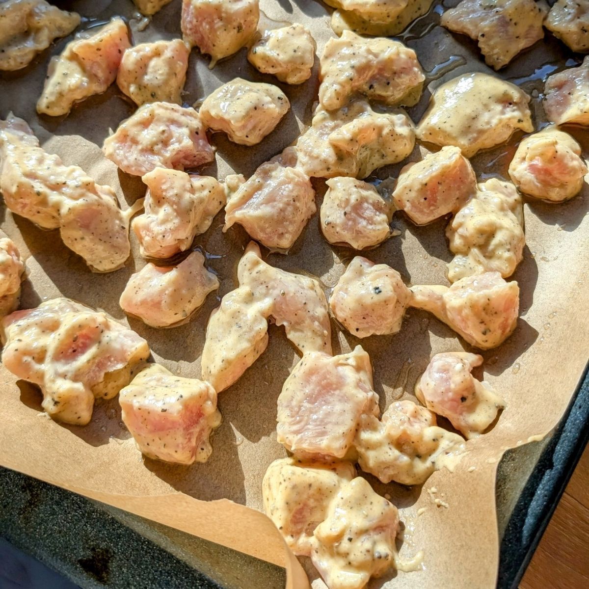 low salt orange chicken on a baking tray for the oven to be tossed with orange sauce