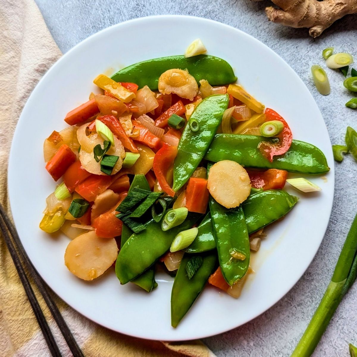 low sodium stir fry with vegetables on a plate with peapods, water chestnuts, carrots, and peppers.