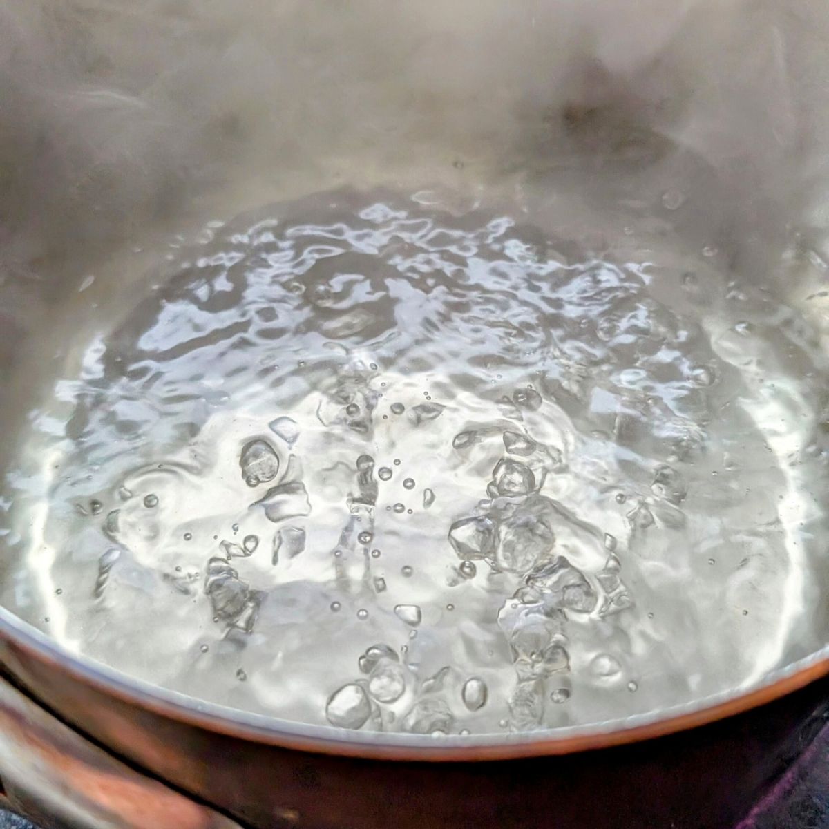 lightly boiling water in a pan for poached eggs for egg benedict no salt