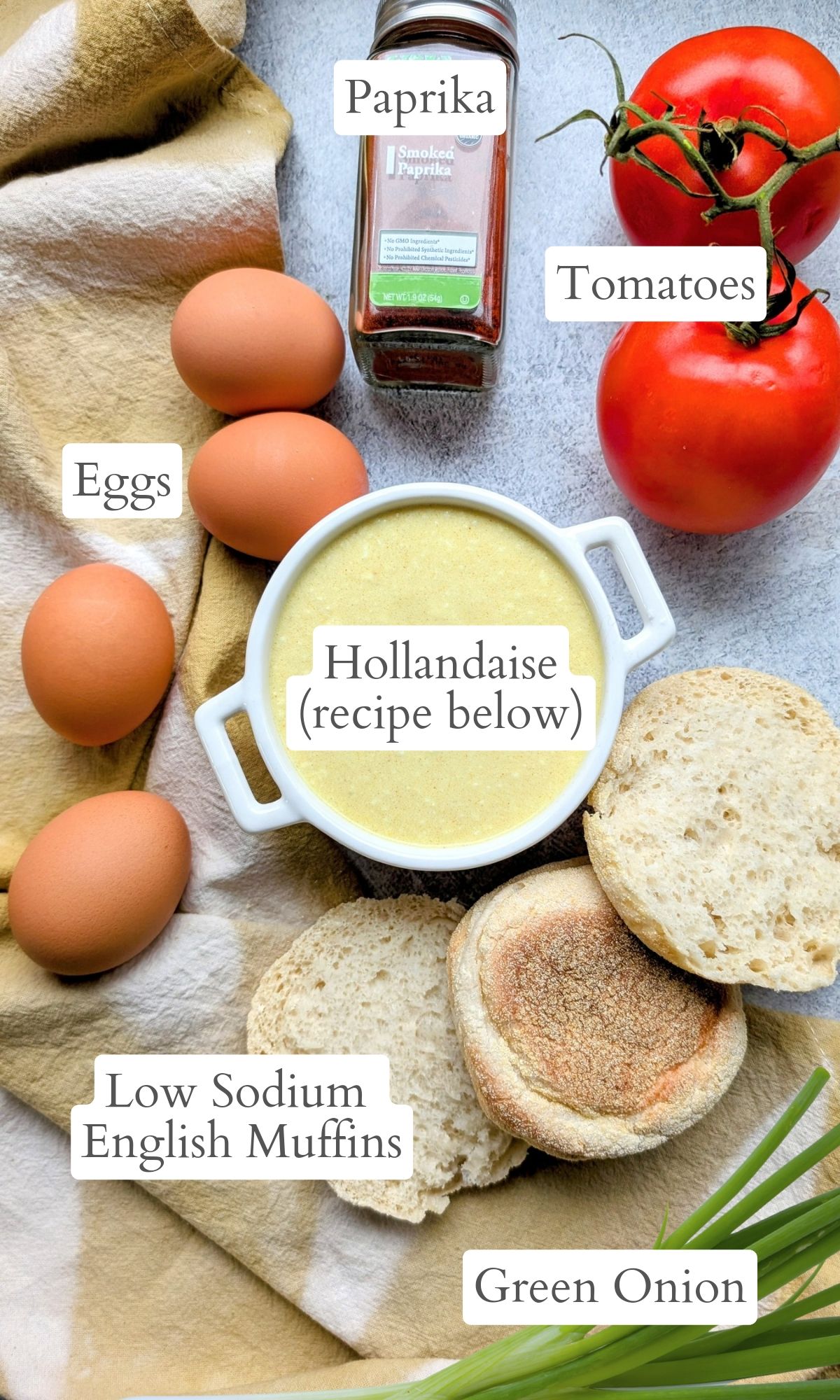 ingredients for salt free eggs benedict including a low sodium hollandaise sauce, tomatoes, english muffins, green onions, and paprika