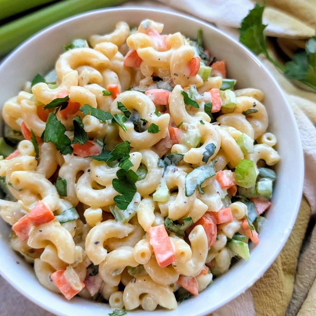 a creamy bowl of mac salad with fresh vegetables and a cream pasta salad dressing.