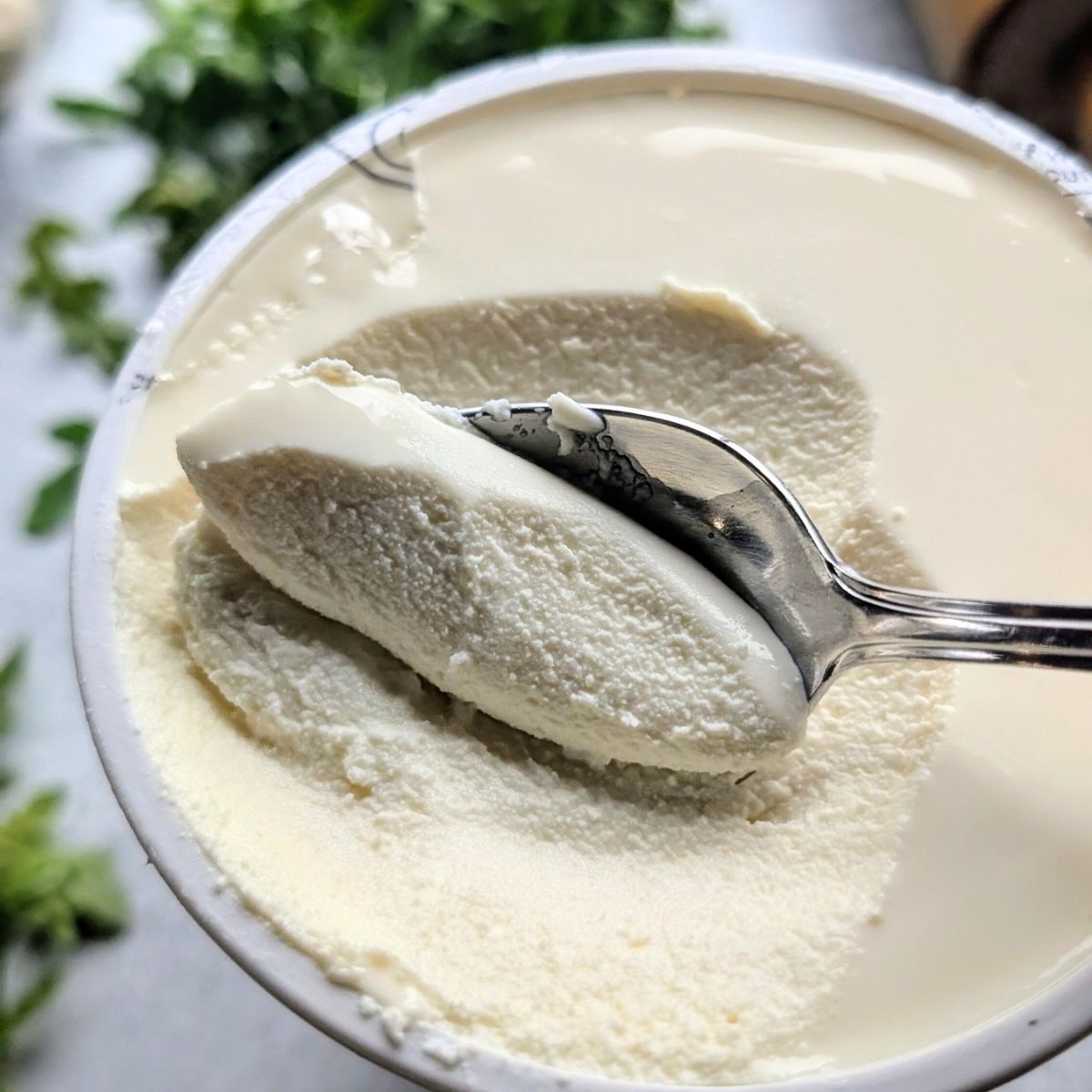 a spoon scooping out thin dollops of ricotta cheese for low sodium pizza