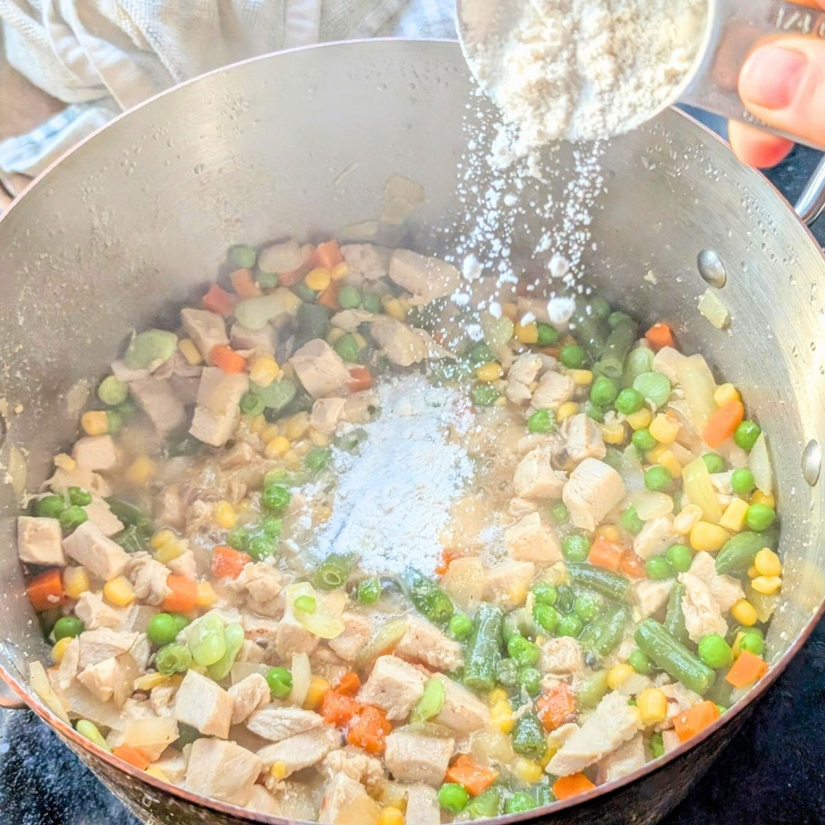 flour sprinkled into a low sodium chicken pie for a roux with unsalted butter and vegetables