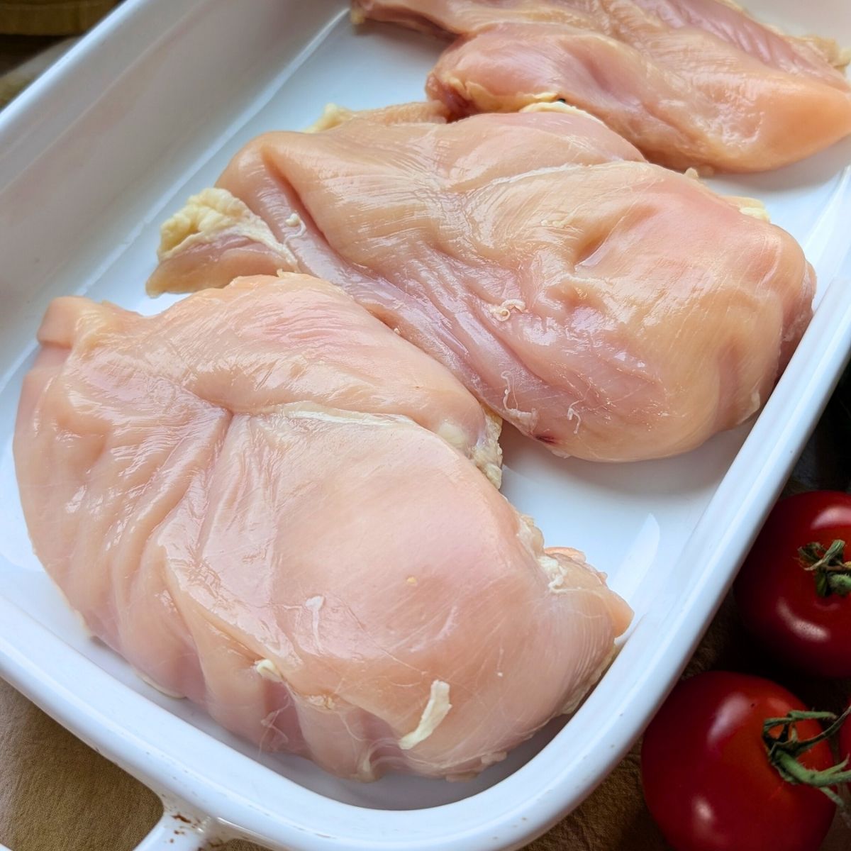 low sodium chicken breasts in a baking dish for italian baked chicken with tomatoes and cheese