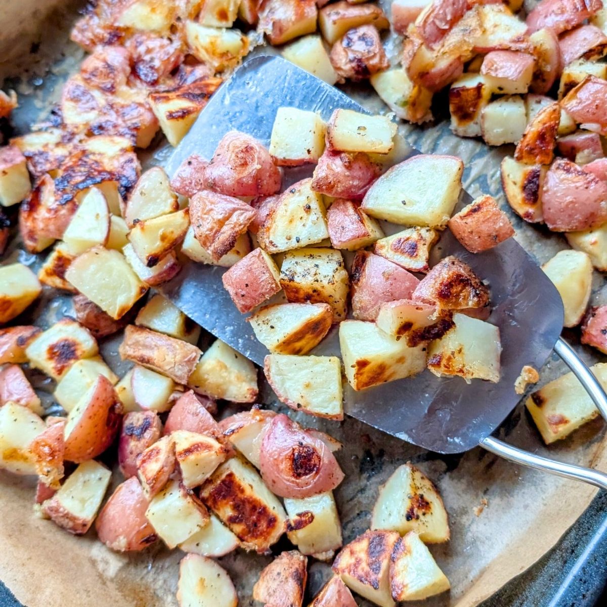 a spatula flipping potatoes for a salt-free side dish you can make in the oven