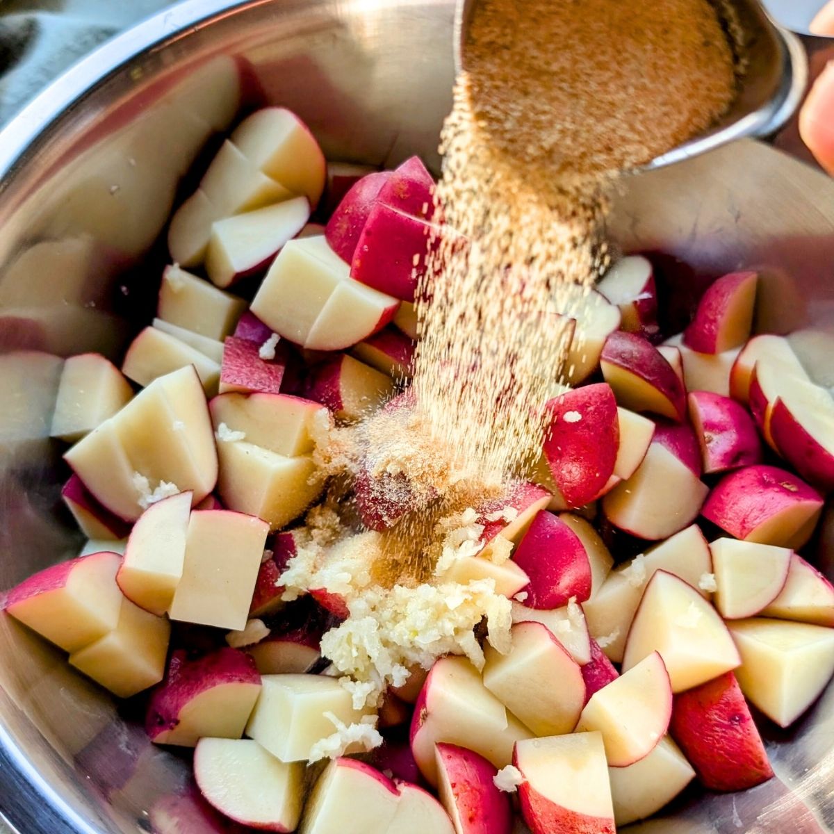 diced potatoes in a bowl to roast with garlic powder and spices