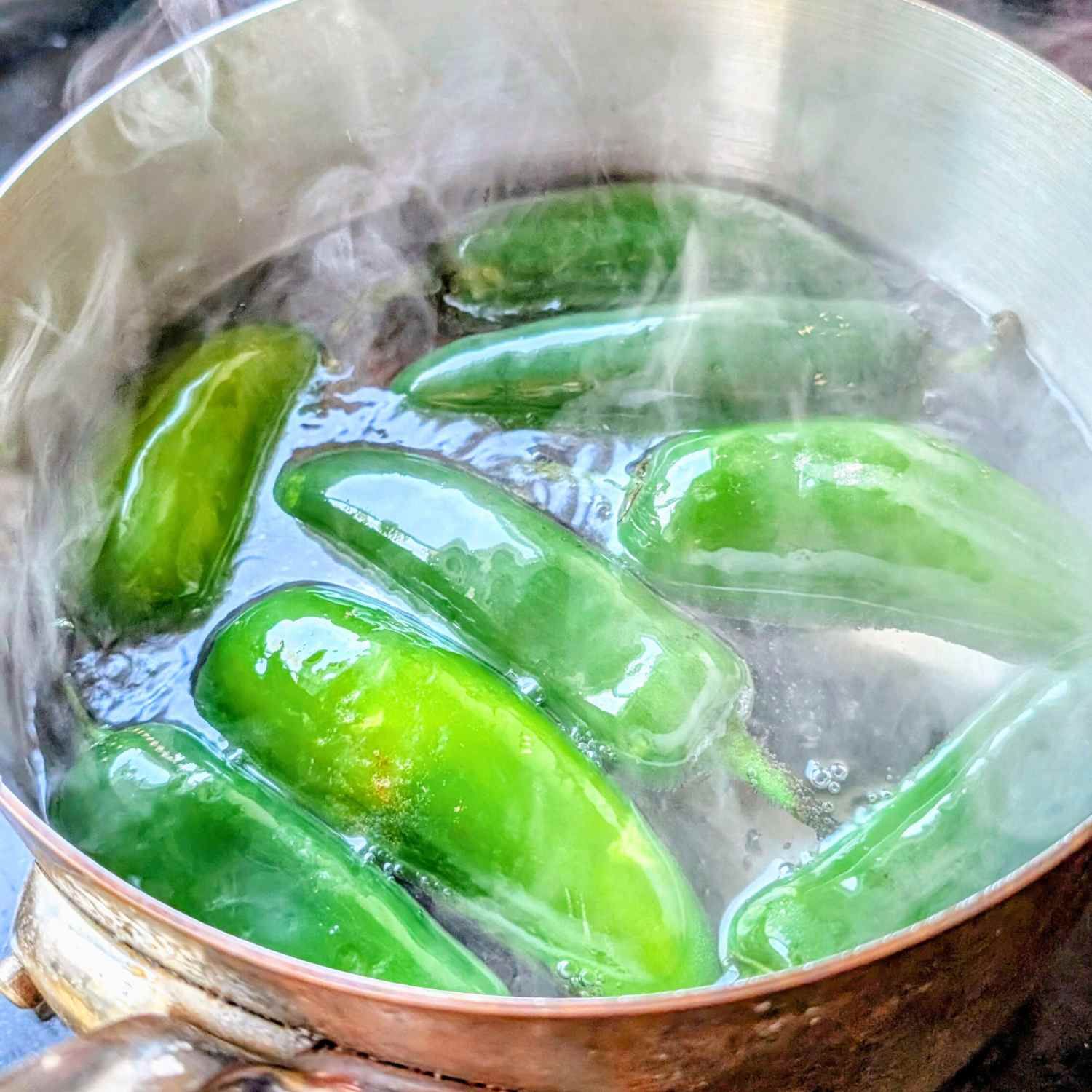 jalapenos in water being boiled for jalapeno poppers with low sodium crean cheese