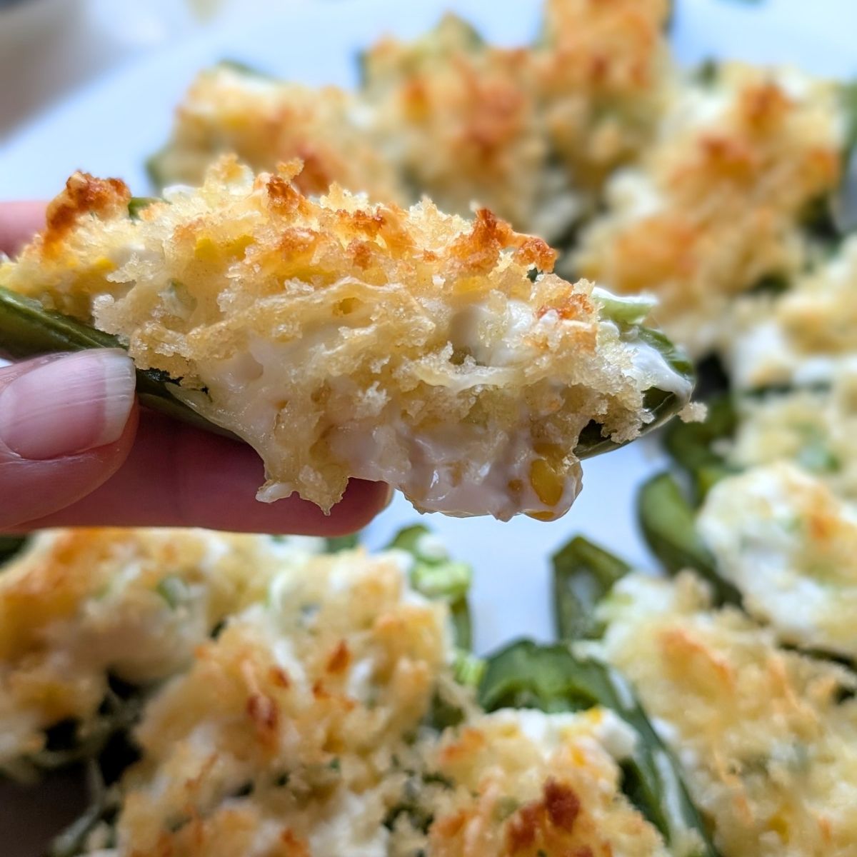 a hand holding a low salt jalapeno popper appetizer for a party or side dish.