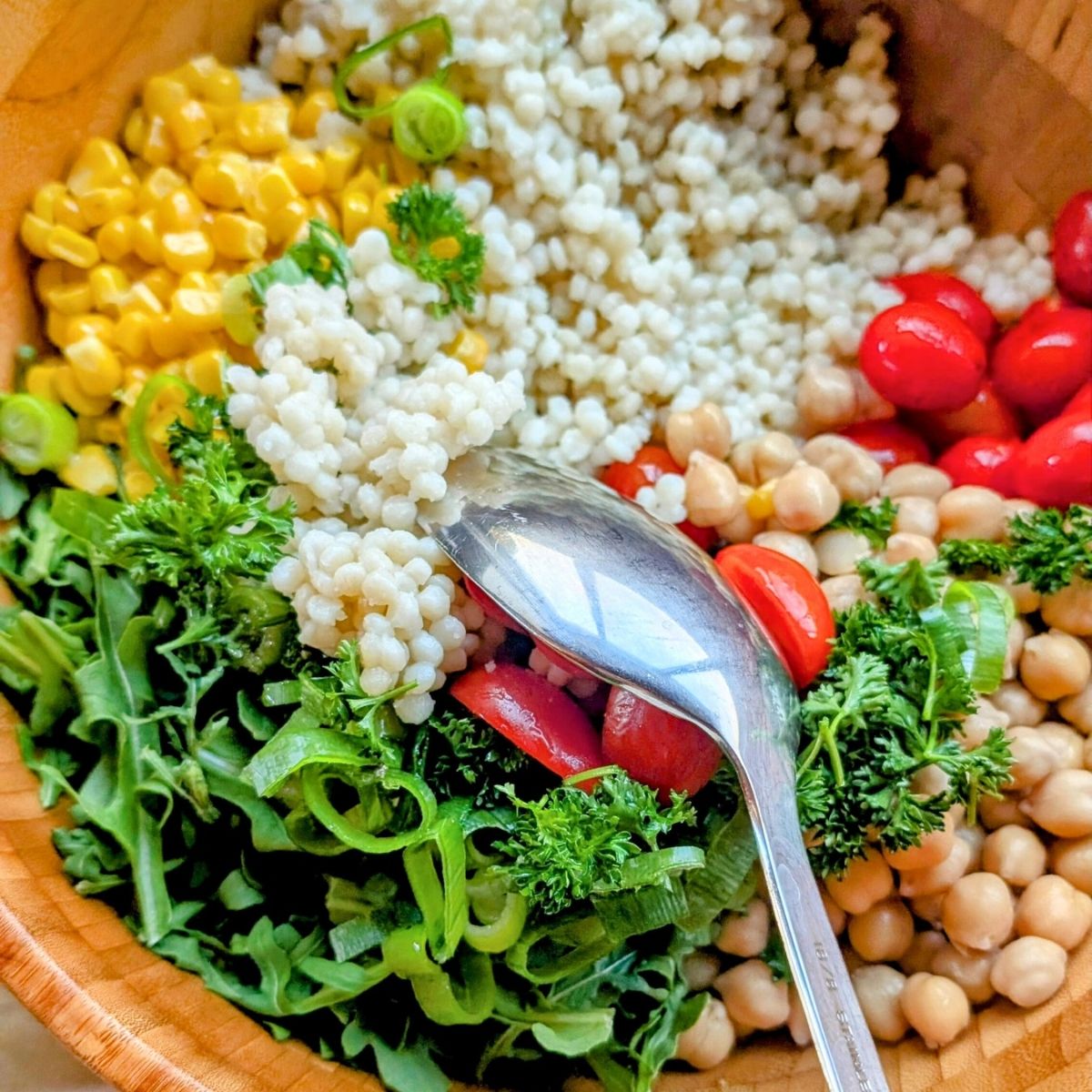 a spoon stirring salt-free salad recipes with vegetables.