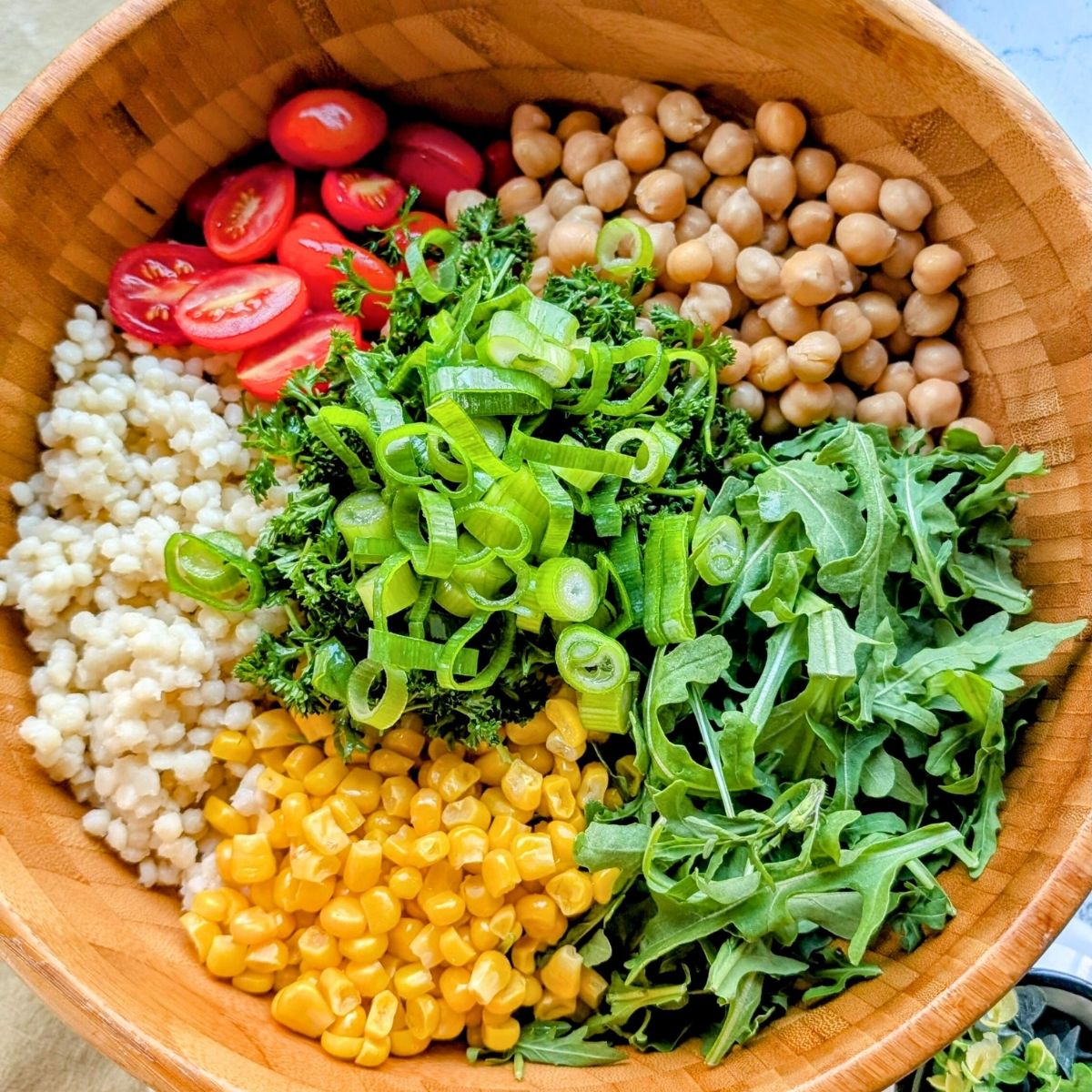 a bowl of salt-free couscous with fresh tomatoes, arugula, corn, chickpeas, and tomatoes.