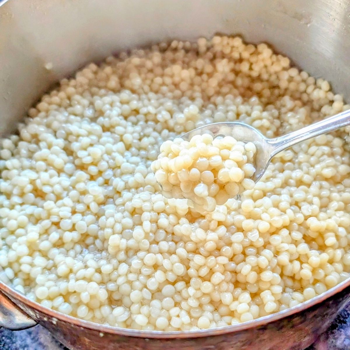 pearl couscous in a pot cooking with water and no salt added.