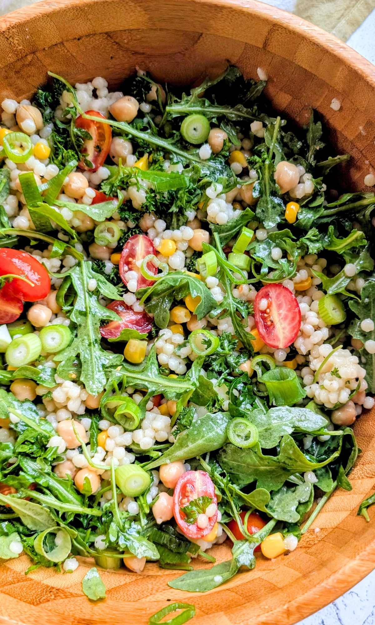 bowls of couscous salad with arugula and fresh vegetables for low sodium potluck salad ideas.