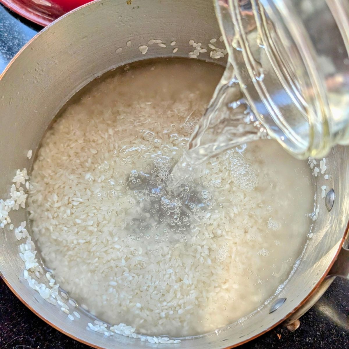 unseasoned rice with water in a pot to make stovetop sticky rice.