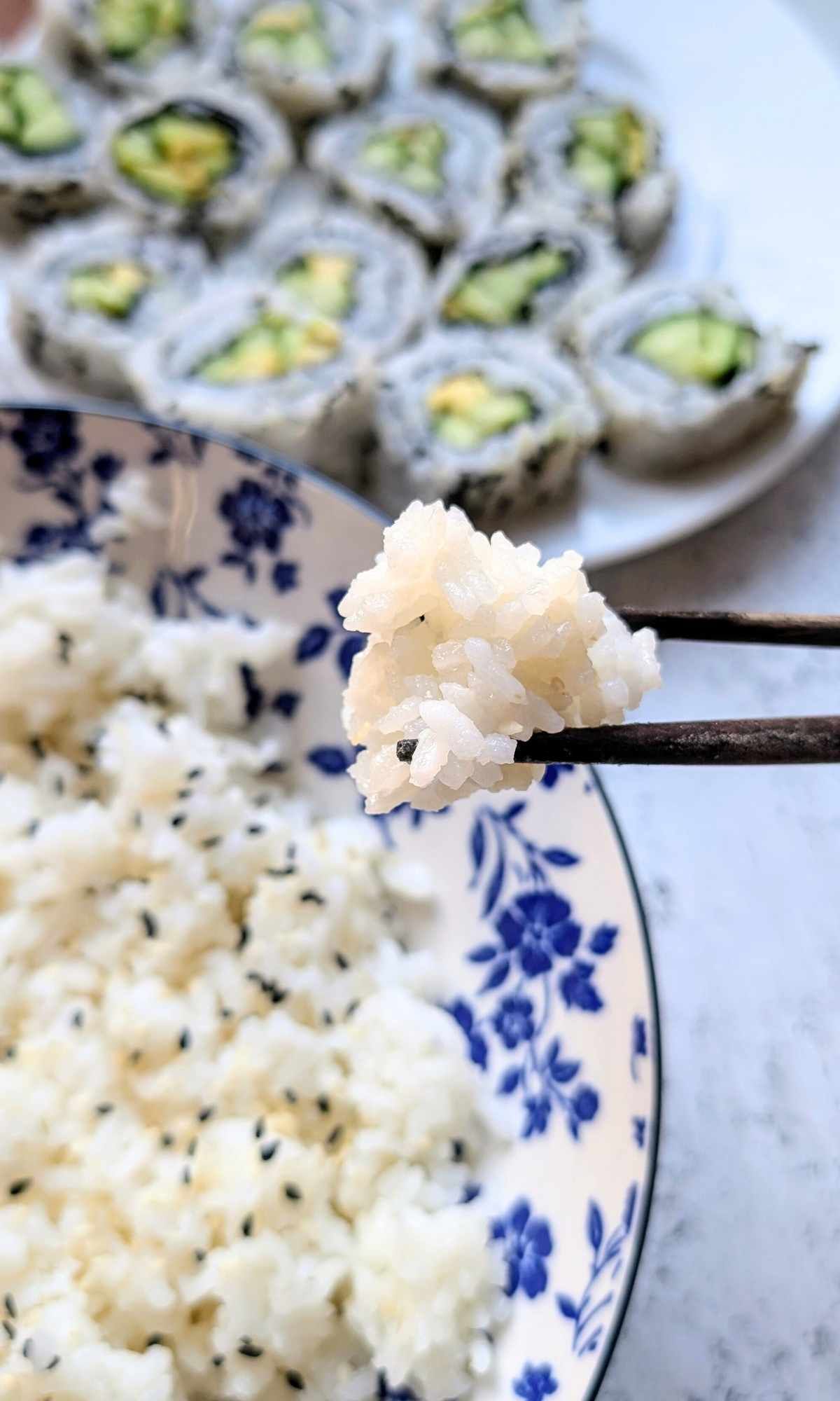 a pair of chopsticks holding sticky rice for dinner without salt