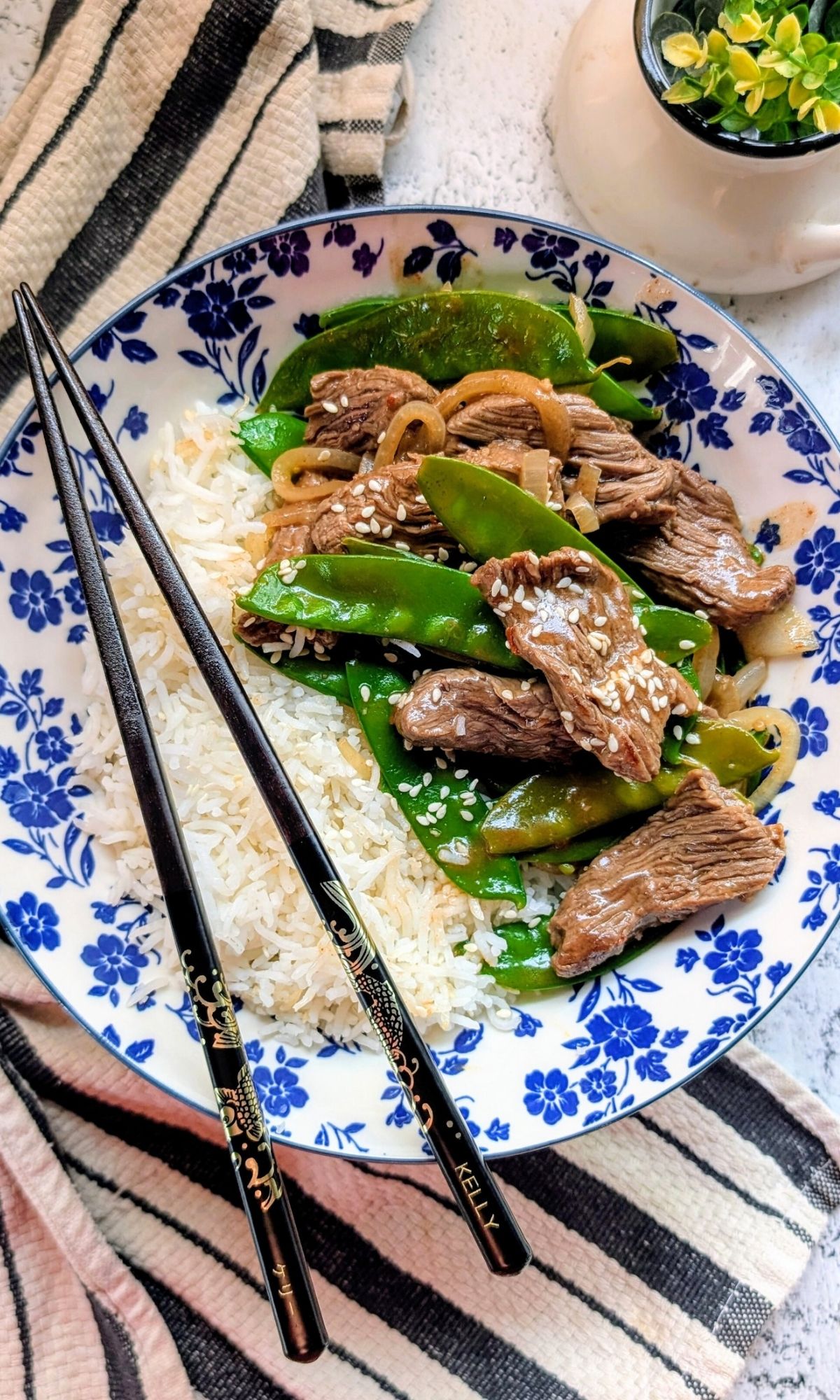 a bowl of low salt teriyaki beef with japanese chopsticks and white steamed rice