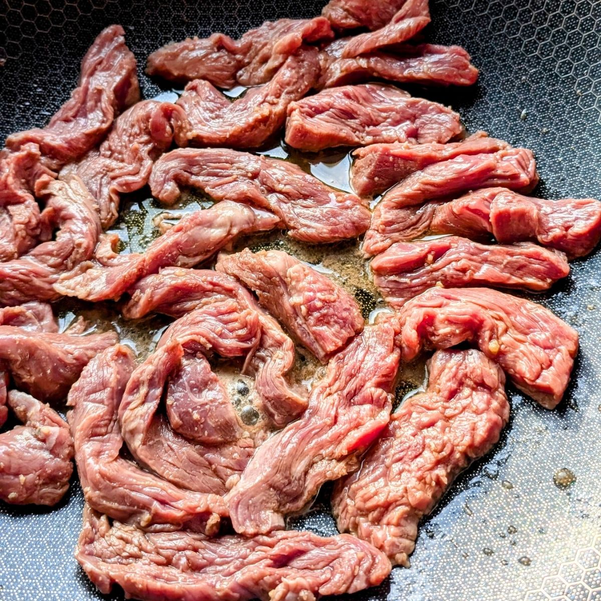 low sodium steak slices in in a wok with sesame oil to make teriyaki beef.