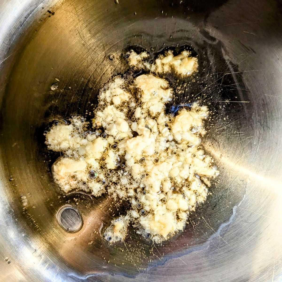 a pot with toasted sesame oil and minced garlic cloves to make miso soup.