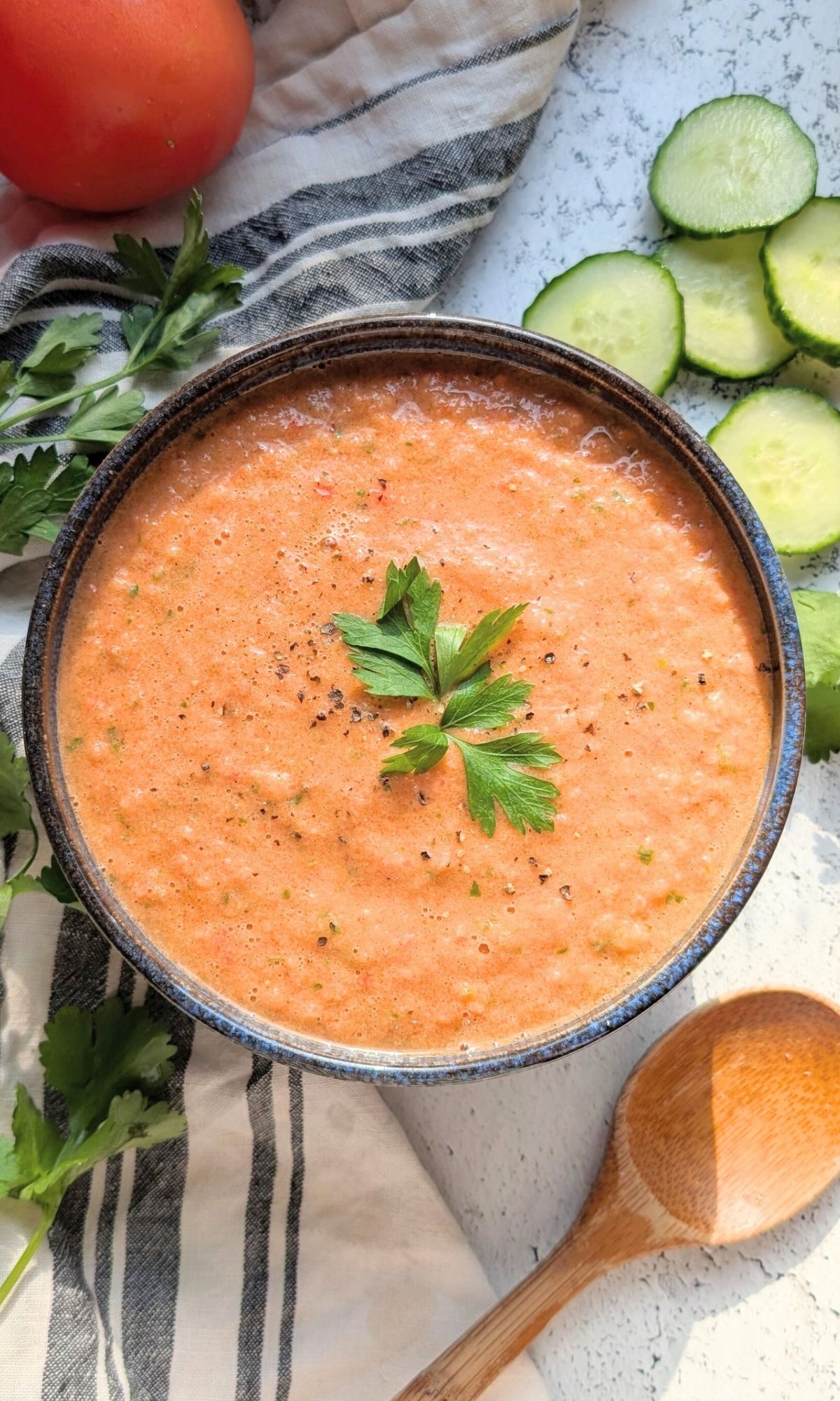 a bowl of low sodium gazpacho tomato soup with cucumber and parsley