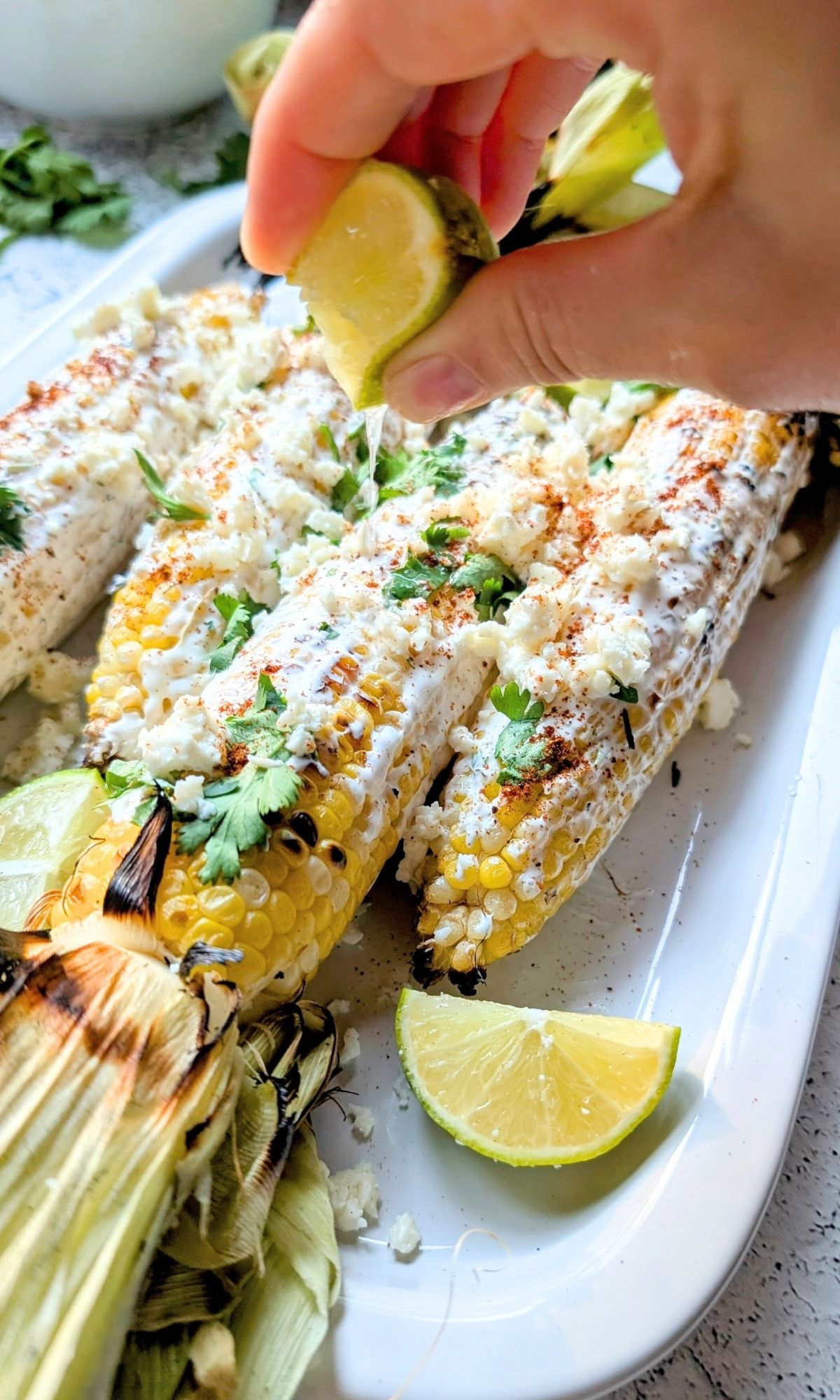 fresh lime juice being squeezed over the low salt  mexican street corn