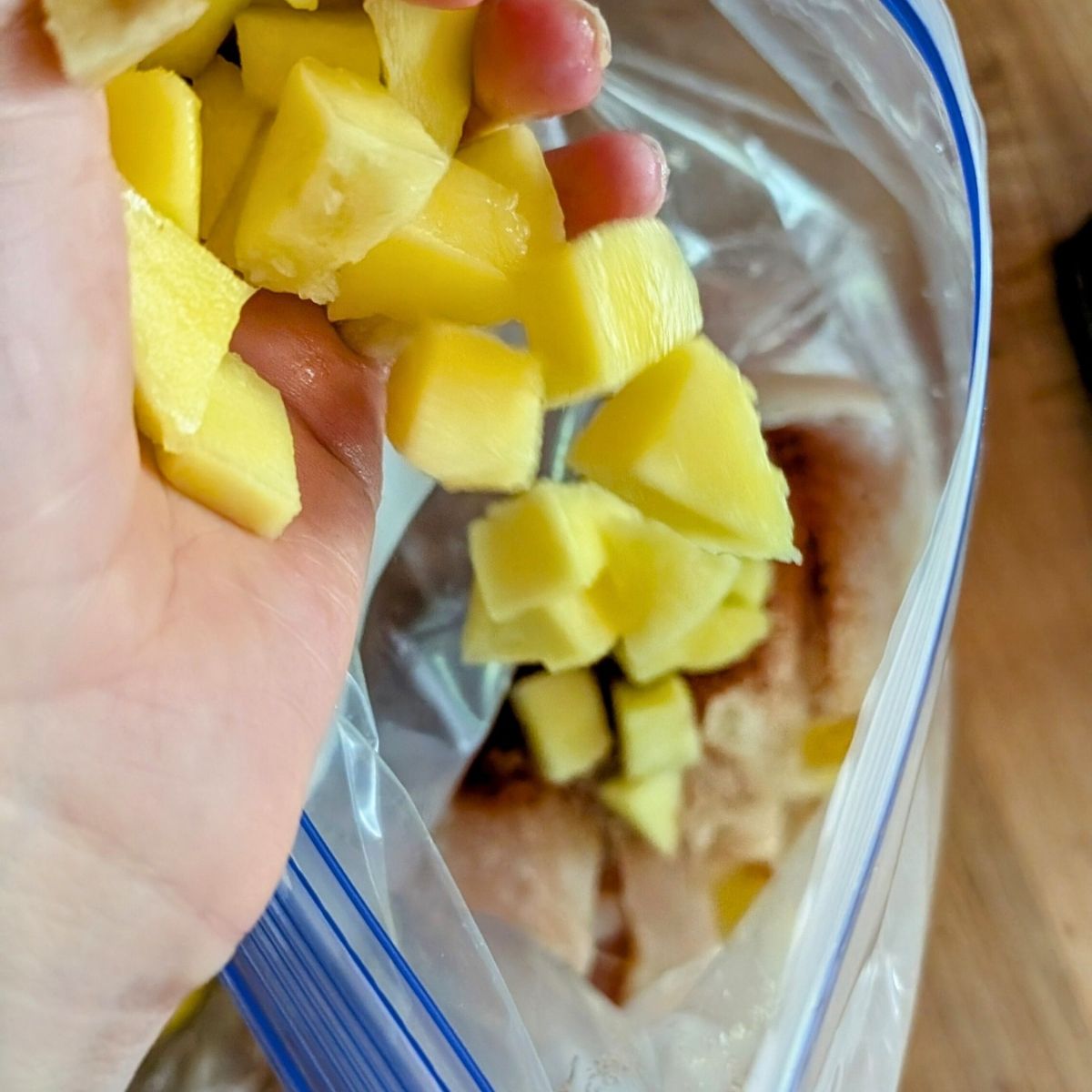 chunks of fresh mango in a plastic bag to marinate chicken without salt