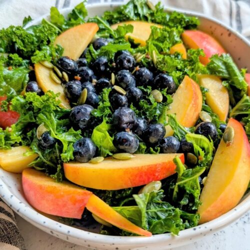 low sodium kale salad with peaches and blueberries in a bowl with a salt free salad dressing