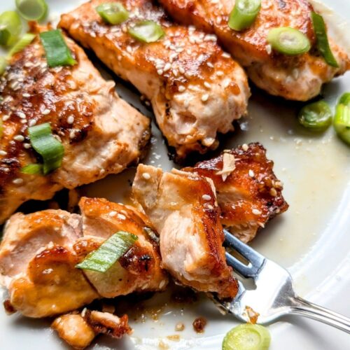 filets of low sodium honey salmon on a plate with green onions and sesame seeds